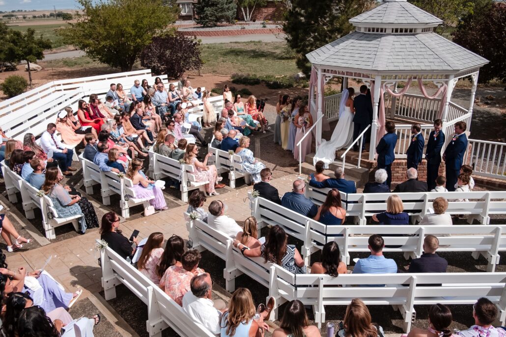 Garden wedding ceremony with guests seated around the Meadows gazebo